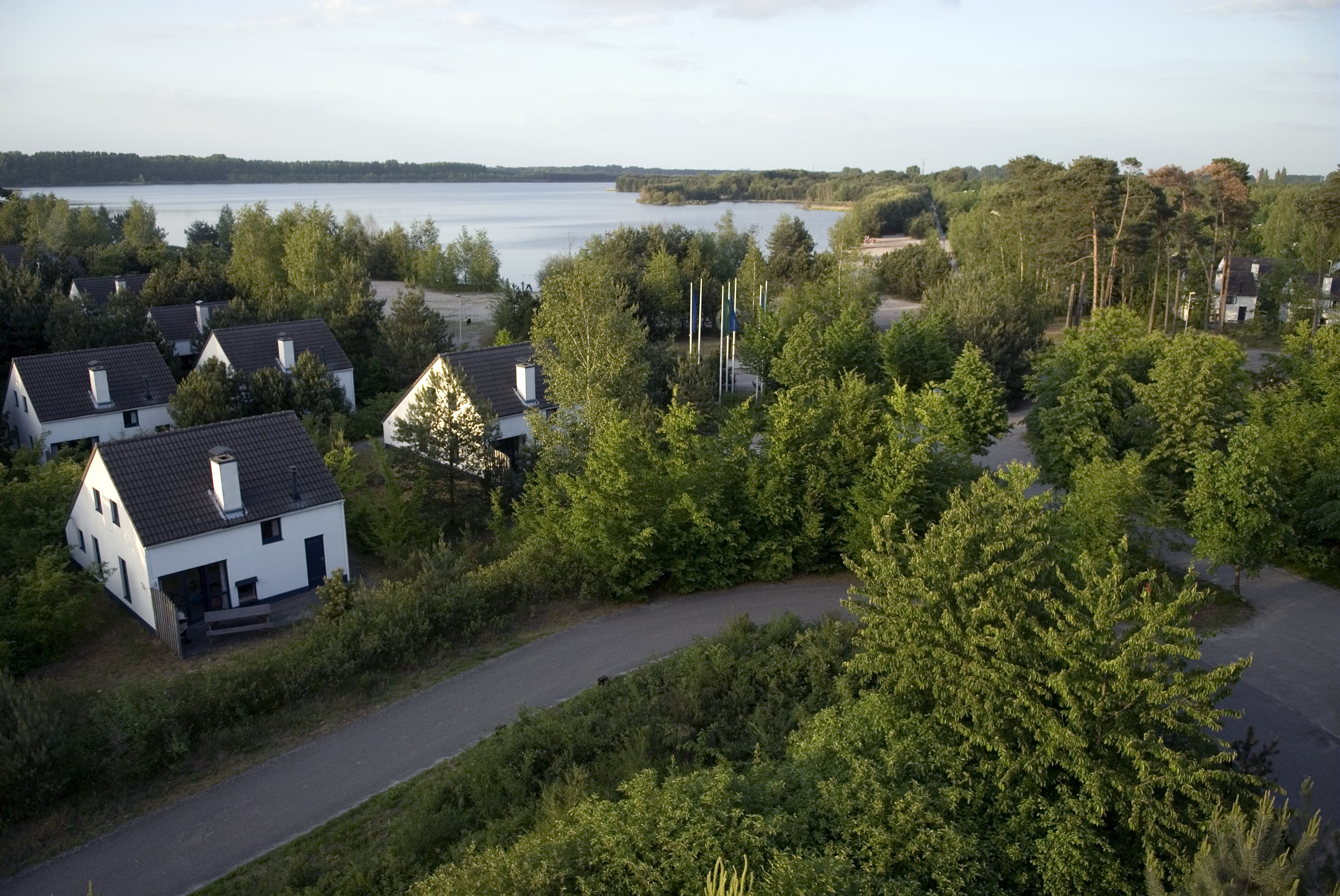 luchtfoto van vakantiehuisjes aan meer in bosachtig gebied